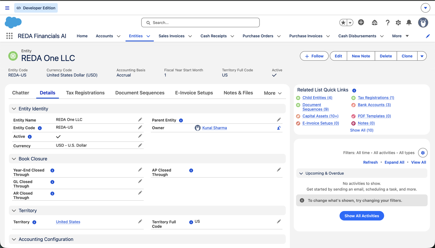 Une page d’enregistrement d’entité dans REDA Financials AI pour REDA One LLC. Le panneau de surbrillance affiche Code d’entité (REDA-US), Code de devise (United States Dollar), Base comptable (Engagement), Mois de début d’exercice (1), Code complet de territoire (US) et Actif. L’onglet Détails affiche les sections Identité de l’entité, Clôture des livres, Territoire et Configuration comptable, et le panneau Liens rapides des listes associées renvoie vers les entités filles, les séquences de documents, les immobilisations, les immatriculations fiscales, les comptes bancaires et les modèles de PDF.